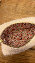 Intérieur de la trousse de maquillage en moumoute blanche avec doublure en coton rose pour un cadeau de Noel